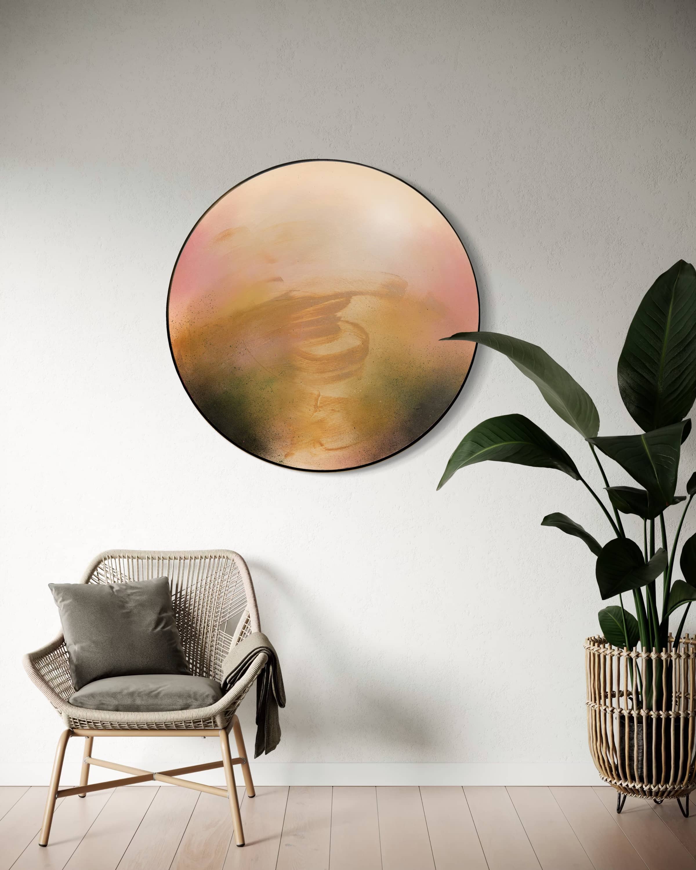 Kindling by Kate Mayer, a circular plywood art piece in a handmade metal frame, hangs above a wicker chair.