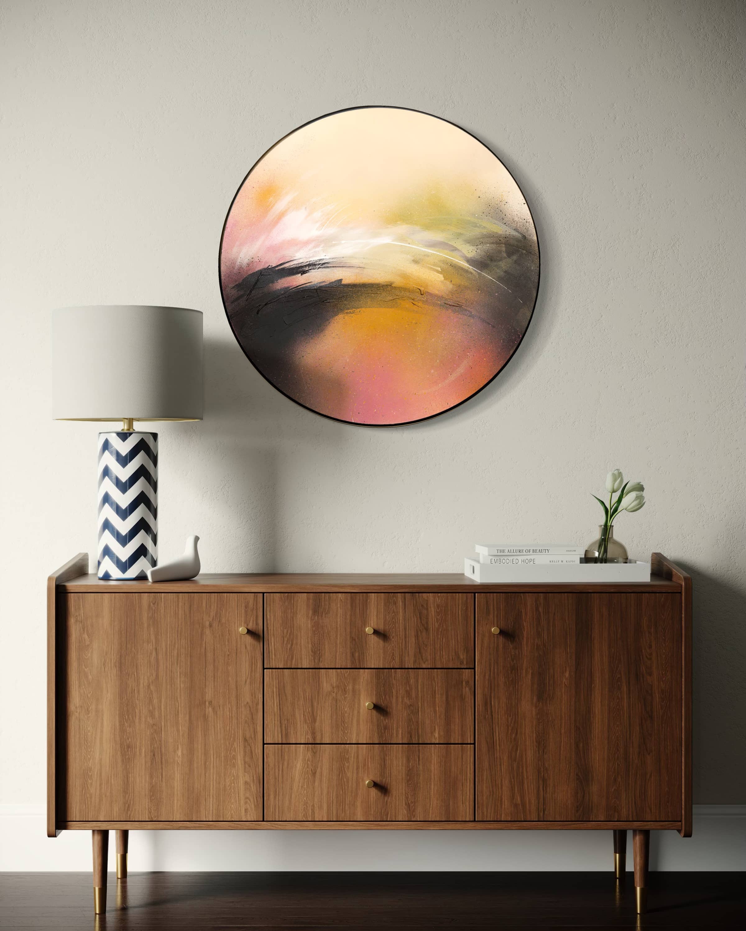 A wooden sideboard with decor sits below the "One Day Like This" artwork by Kate Mayer on a light wall.