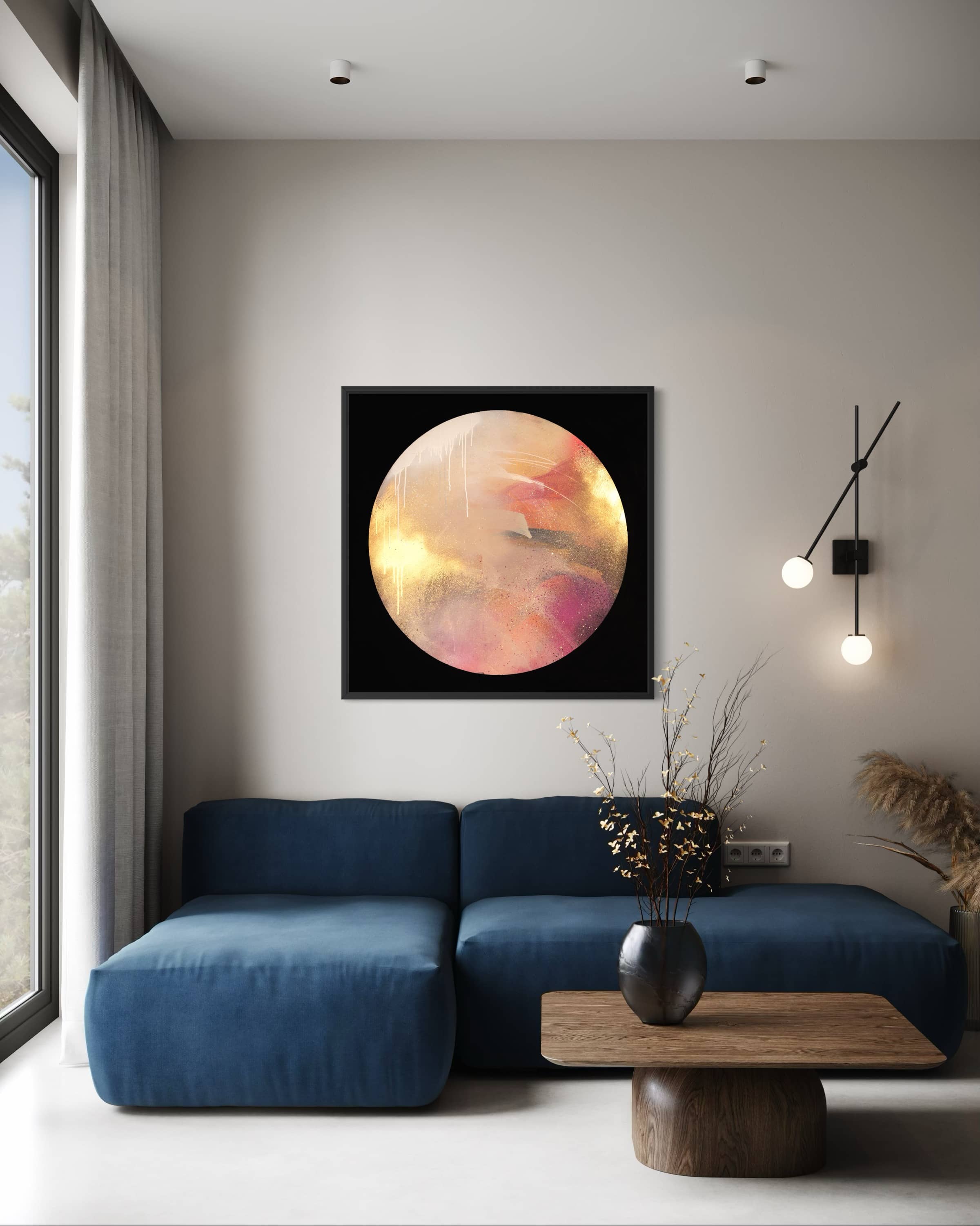 Modern living room with a blue sofa, round table, and "Where Love Lives" by Kate Mayer on the wall.
