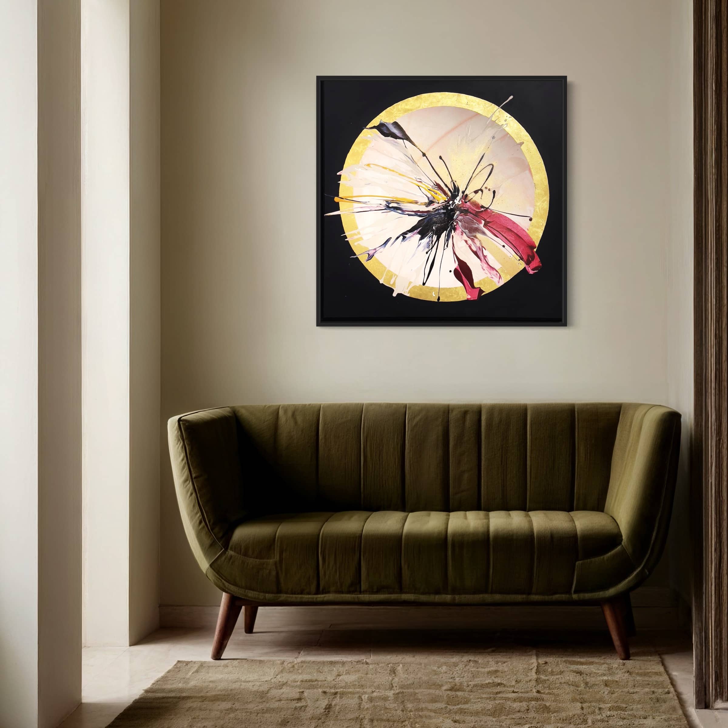 Minimalist room with an olive green sofa, beige walls, light carpet, and "Expansions," an original painting by Kate Mayer, featuring a yellow circle and splashes of acrylic and gold leaf, ready-to-hang above the sofa.