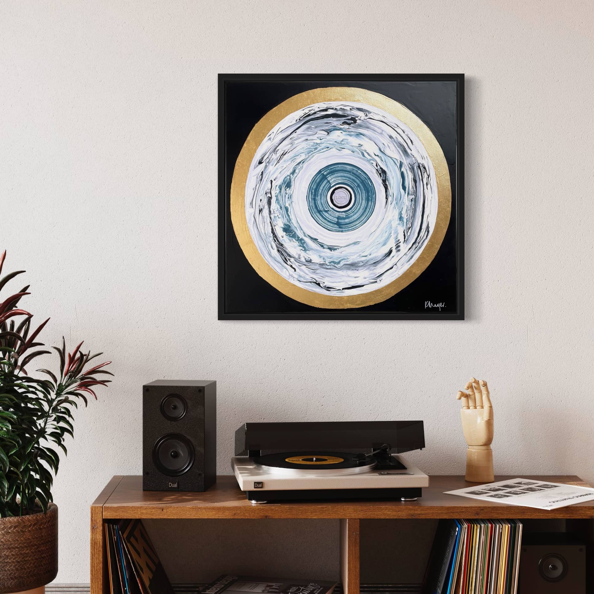 A modern living room features a record player with speakers, a potted plant, and an original abstract painting titled "One Love" by Kate Mayer on a light-colored wall.