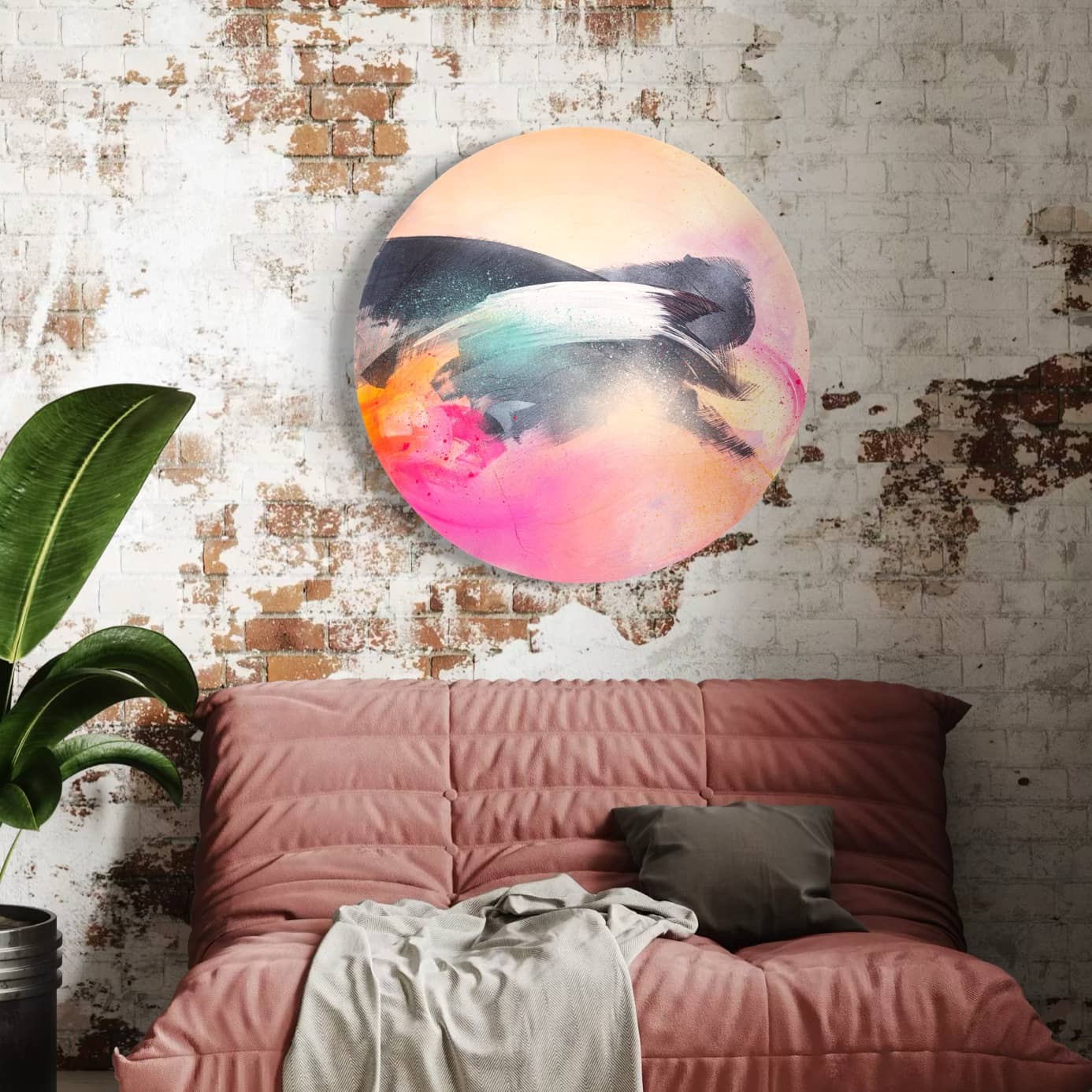 Kate Mayer's "Glow Up" painting decorates a worn brick wall above a pink sofa with pillows.