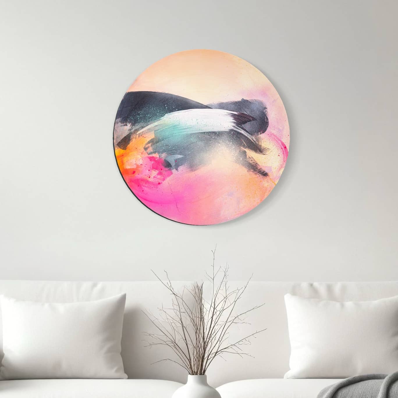 Glow Up" by Kate Mayer, a vibrant acrylic and spray painting, decorates a white wall above a couch with decorative branches.