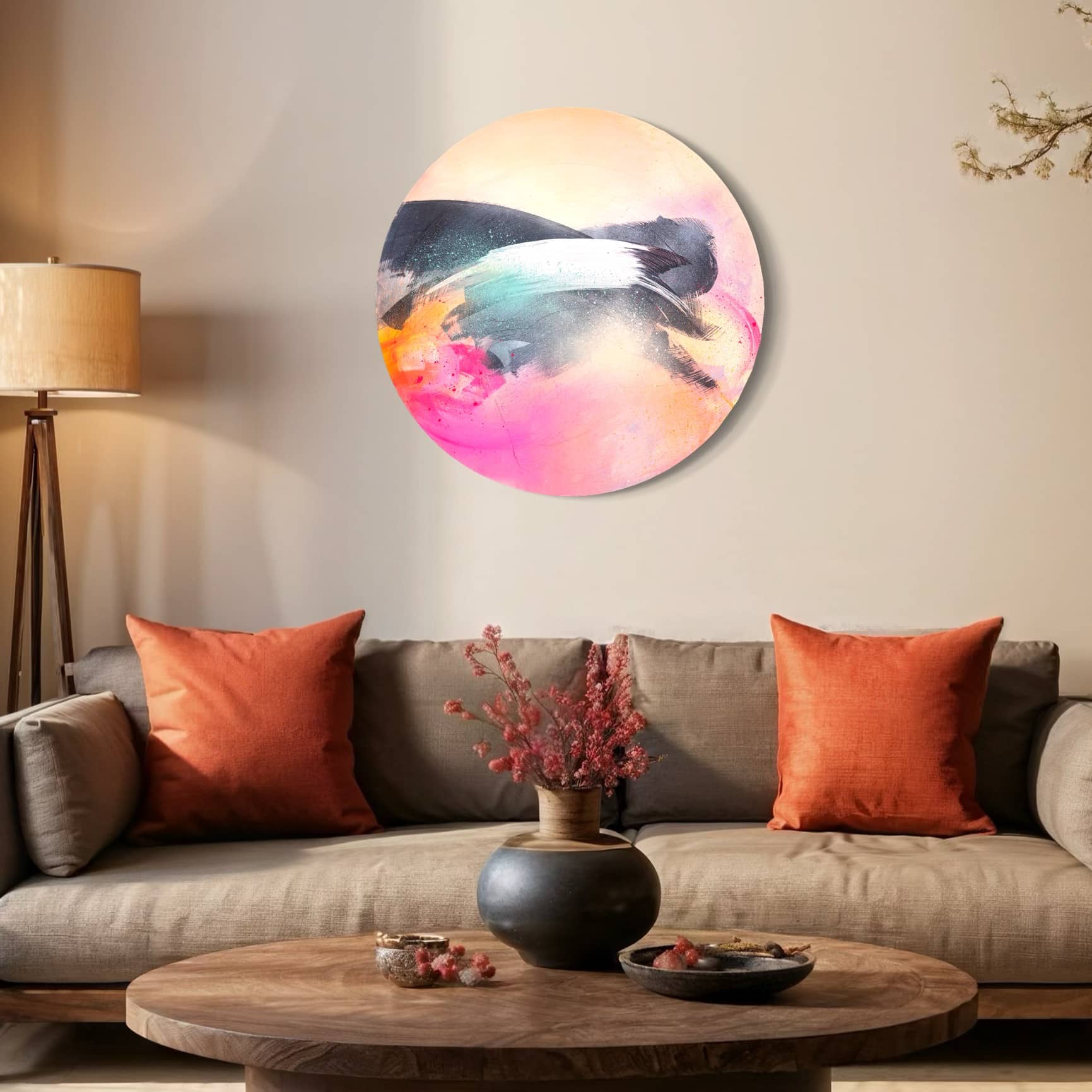 Living room with a gray sofa, orange cushions, Kate Mayer's "Glow Up" painting, floor lamp, and wooden coffee table with a vase.