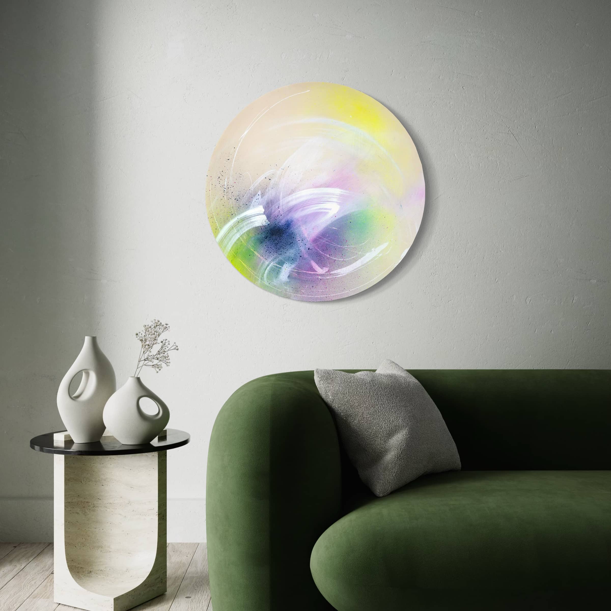 Modern living room with a green sofa, side table, and 'I Believe In Miracles' by Kate Mayer on the wall.