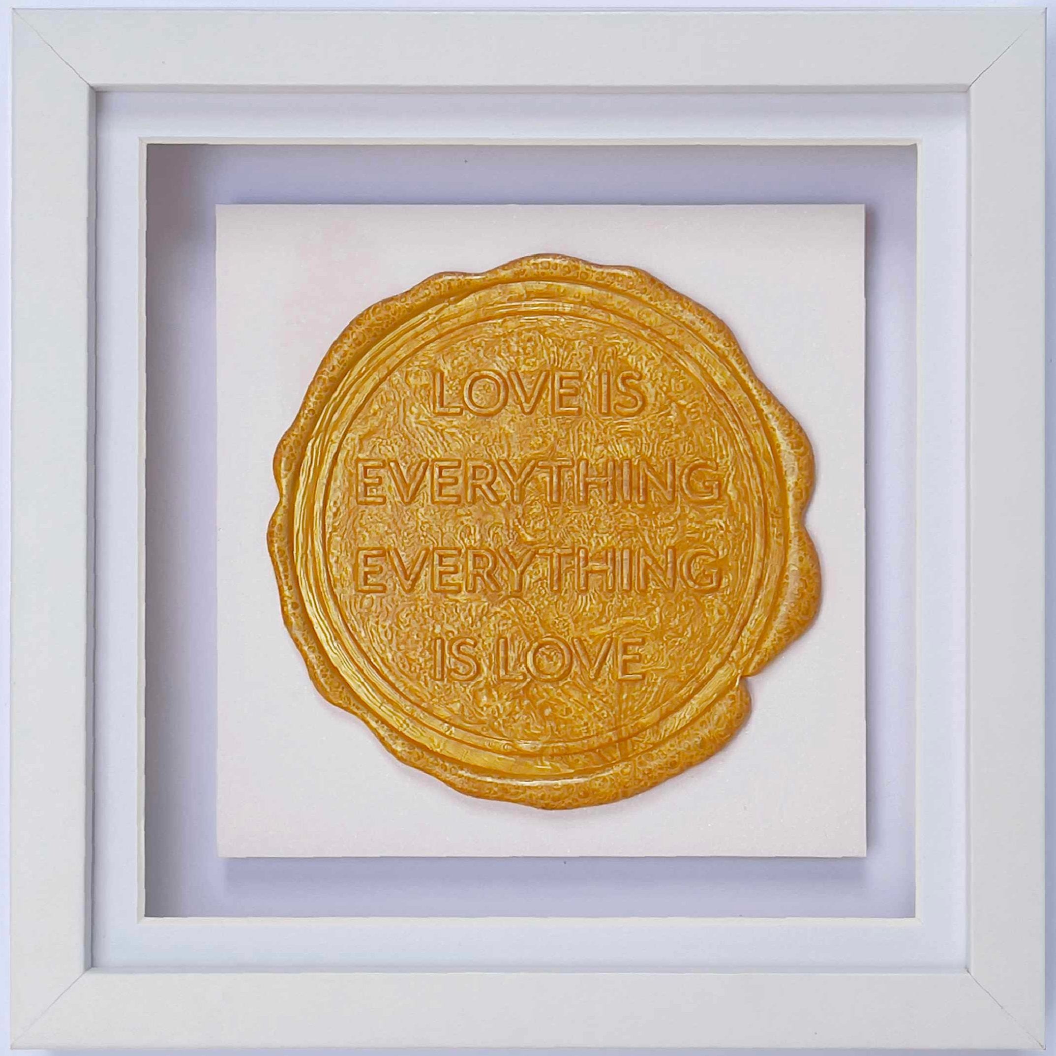 Framed in a white shadow frame, "Sealed Intention for LOVE" by Kate Mayer is an original art piece showcasing a bespoke gold wax seal that reads "Love is Everything and Everything is Love" on a pristine white background.