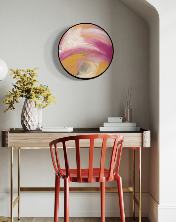 A red chair at a wooden desk, yellow flowers, and “Love’s In Need Of Love Today” by Kate Mayer in a metal float frame.