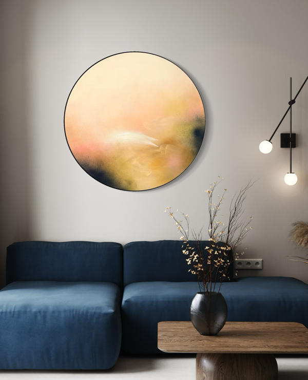 Friend“ by Kate Mayer—pastel abstract art in a metal frame above a blue sofa with modern lighting and vase on wood table.