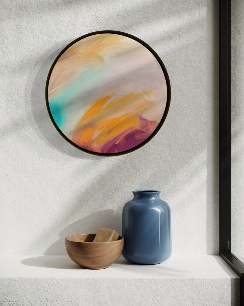 Good Times“ by Kate Mayer, a round acrylic on plywood, sits above a blue vase and bowl on a sunlit white shelf.